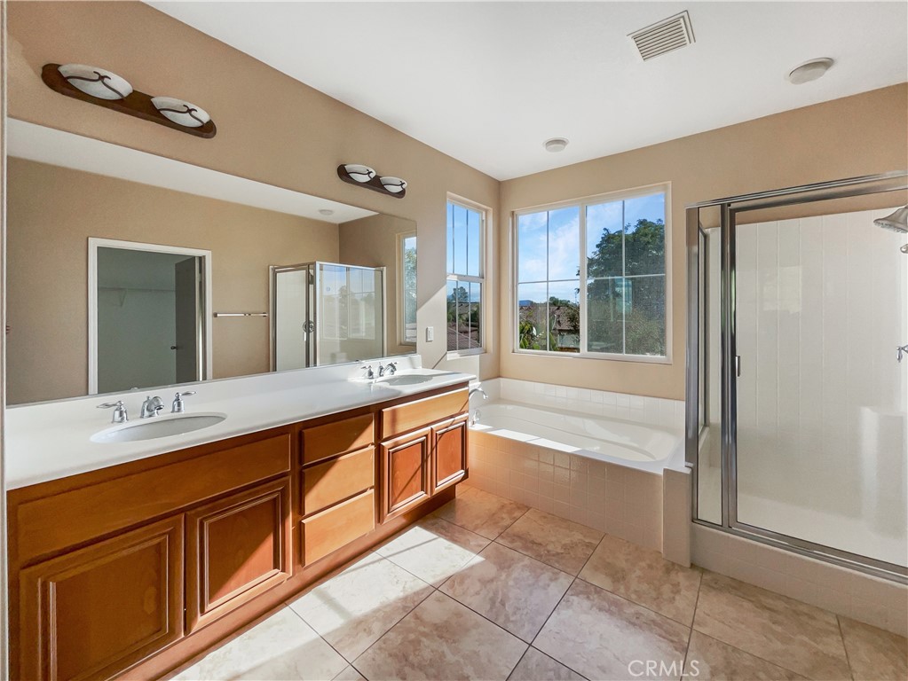 28872 Cedar Brook Lane Menifee, CA 92584 - Photo 22 of 26 a spacious bathroom with a tub sink shower and mirror