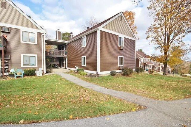 a view of a house with backyard and a tree