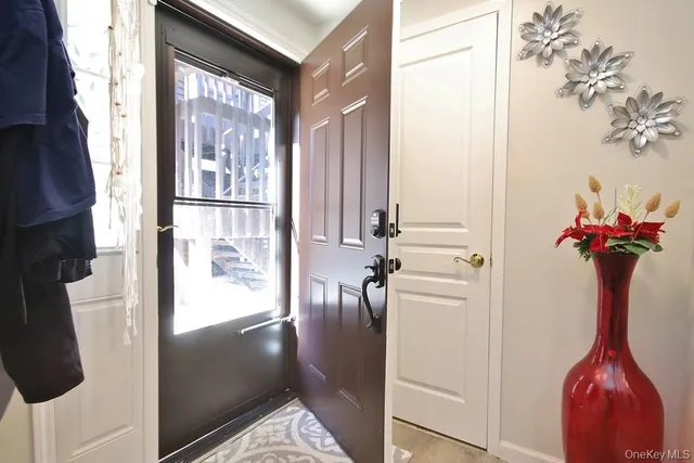 a view of a hallway with furniture and a window