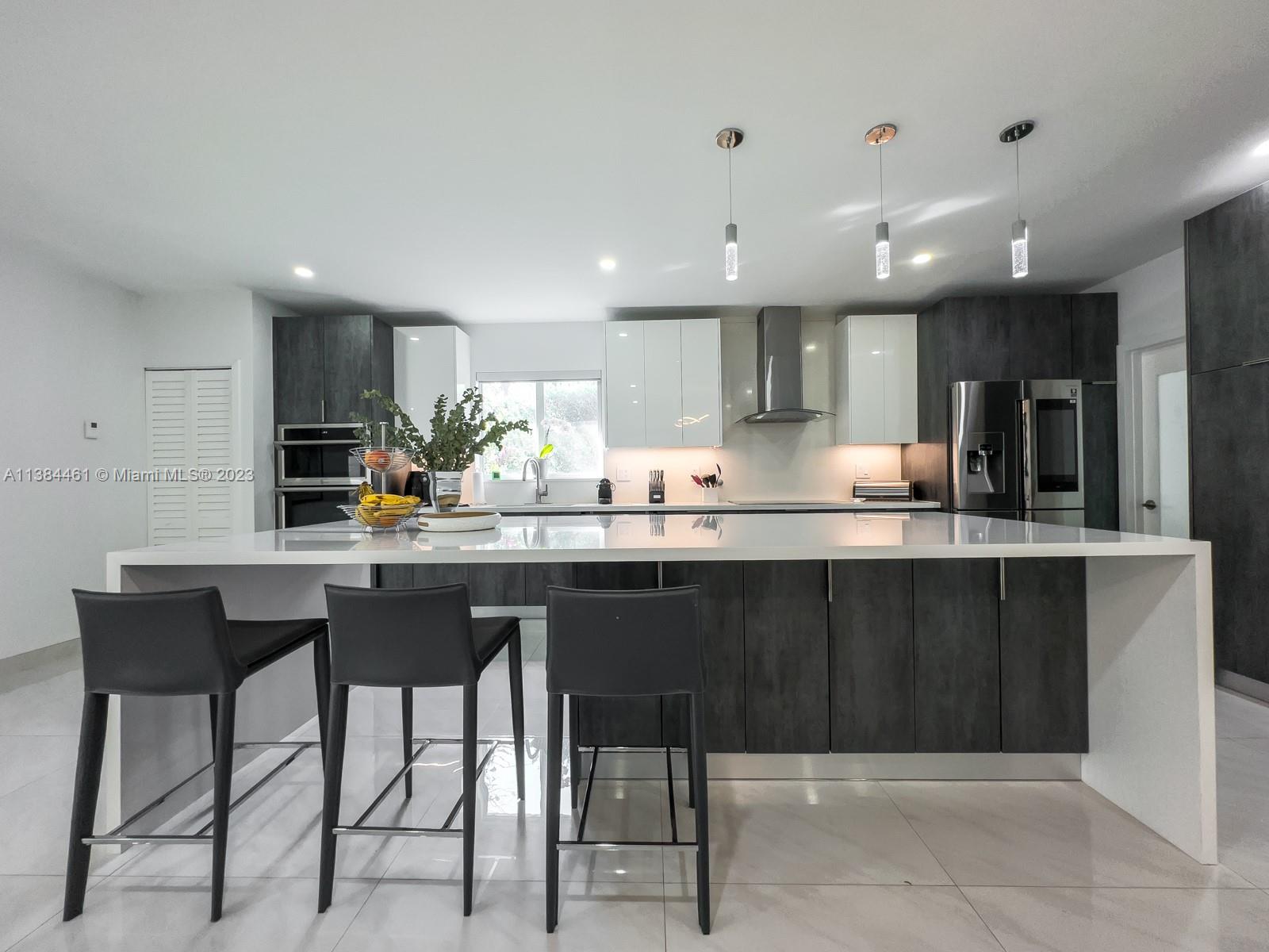 420 Southwest 18th Road Miami, FL 33129 - Photo 9 of 30 a kitchen with granite countertop a table chairs microwave and cabinets