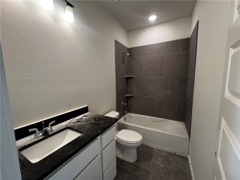 4756 Holm Oak Road Bryan, TX 77845 - Photo 11 of 13 a bathroom with a granite countertop sink toilet and shower