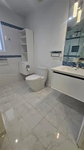 a view of a kitchen with a sink and dishwasher a stove top oven with wooden floor