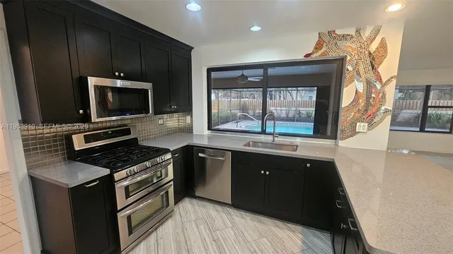 a kitchen with granite countertop a stove and a sink