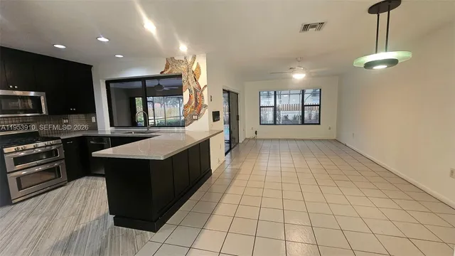 a kitchen with stainless steel appliances granite countertop a stove a sink and a microwave