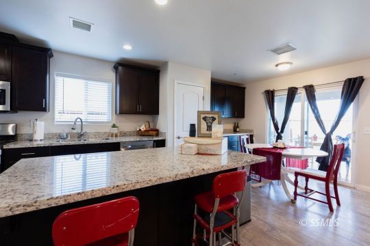 916 South Farragut Street Ridgecrest, CA 93555 - Photo 12 of 30 a kitchen with stainless steel appliances granite countertop a sink a stove a table and chairs