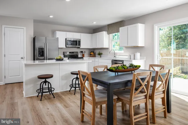 a kitchen with a dining table chairs and microwave