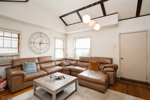 a living room with furniture a large window and a chandelier