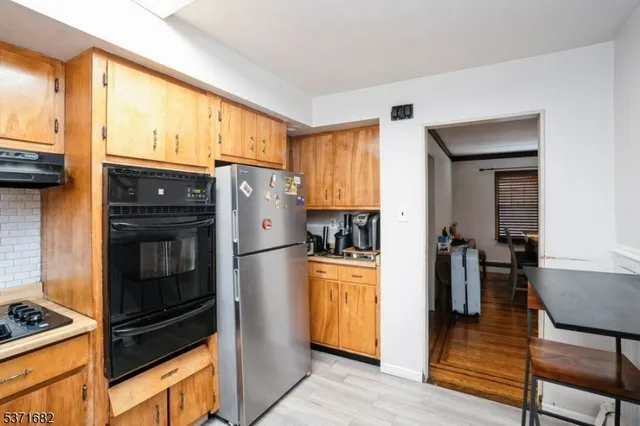 a kitchen with stainless steel appliances granite countertop a refrigerator and a stove top oven