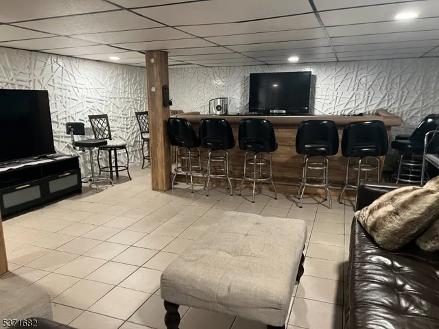 a living room with furniture a flat screen tv and kitchen view