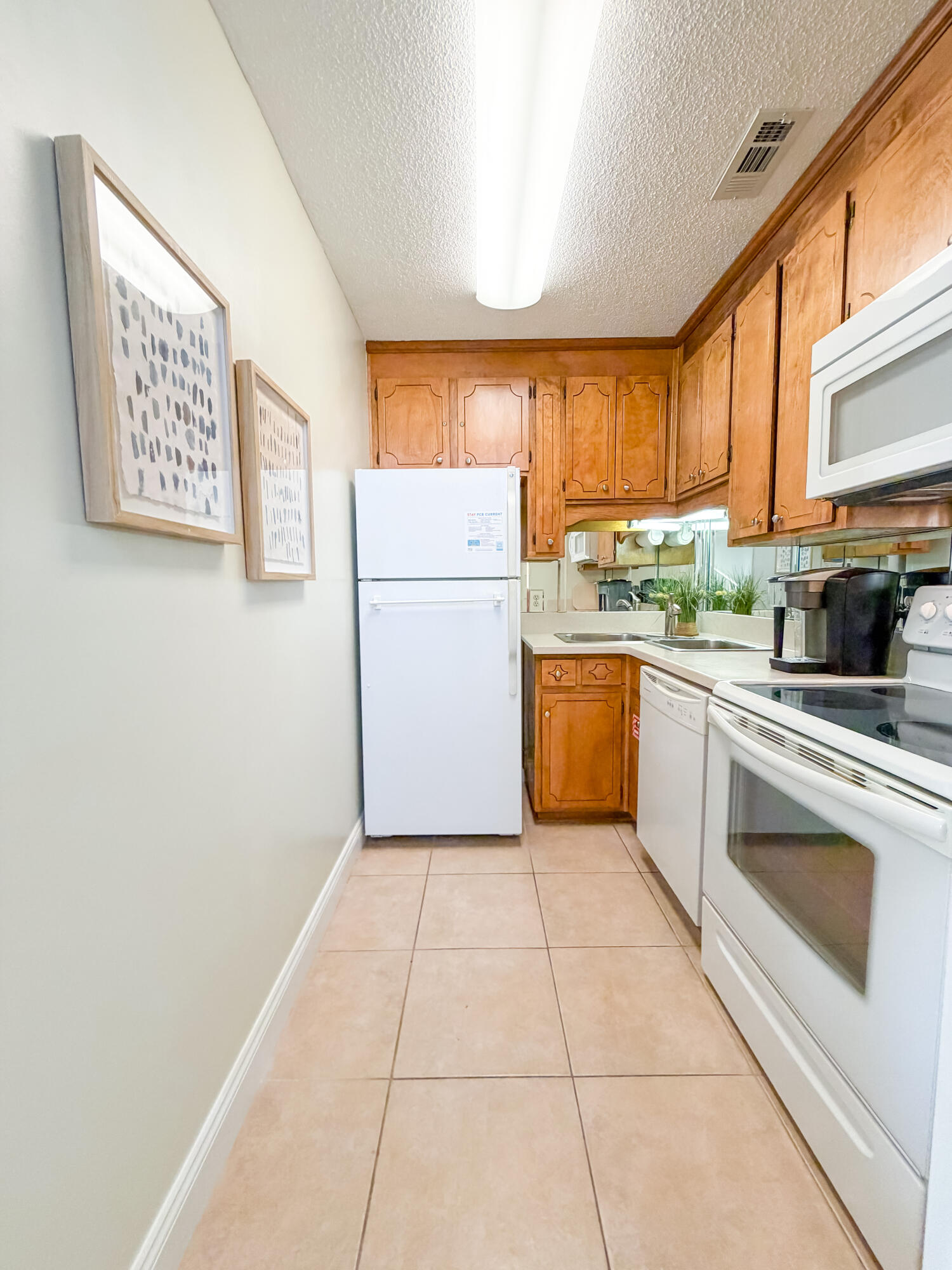 17462 Front Beach Road, Unit 38B Panama City Beach, FL 32413 - Photo 14 of 39 a kitchen with a stove a sink and a refrigerator