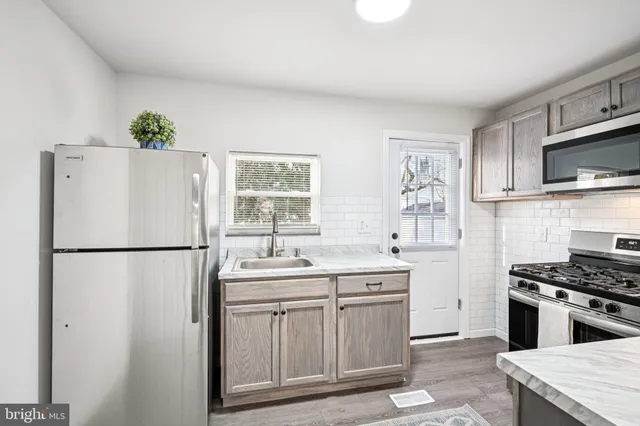 a kitchen with stainless steel appliances a refrigerator sink and stove