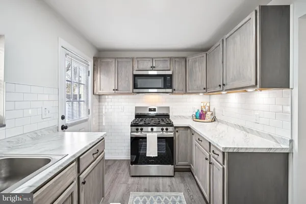 a kitchen with granite countertop a sink stove and cabinets