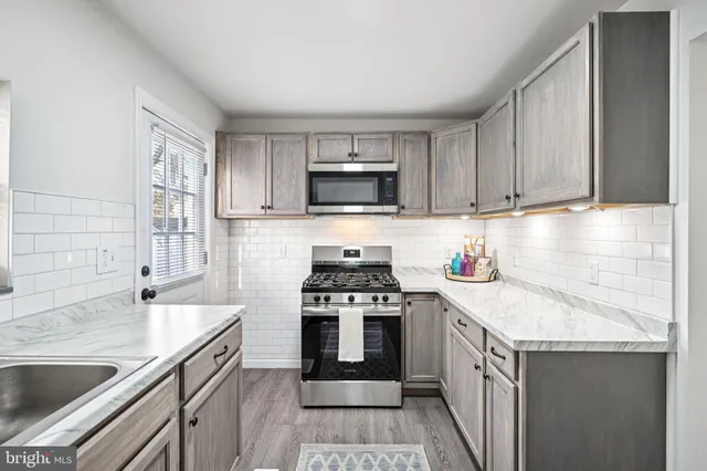 a kitchen with granite countertop a sink stove and cabinets