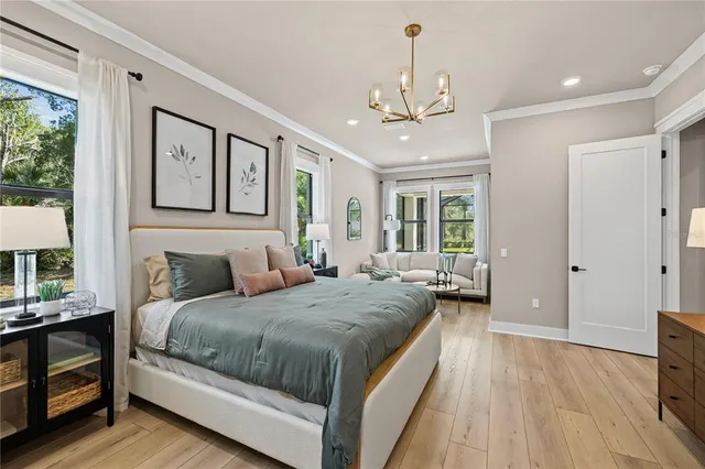 a bedroom with a large bed and a chandelier