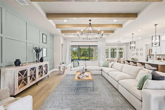 a living room with furniture a dining table and a chandelier