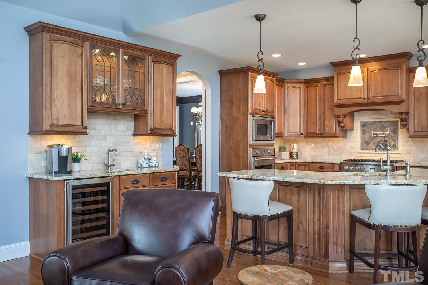 1616 Morning Mountain Road Raleigh, NC 27614 - Photo 17 of 86 a kitchen with granite countertop a stove a sink a dining table and chairs