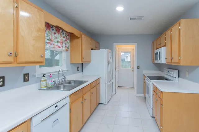 wooden floor in an empty room with a kitchen