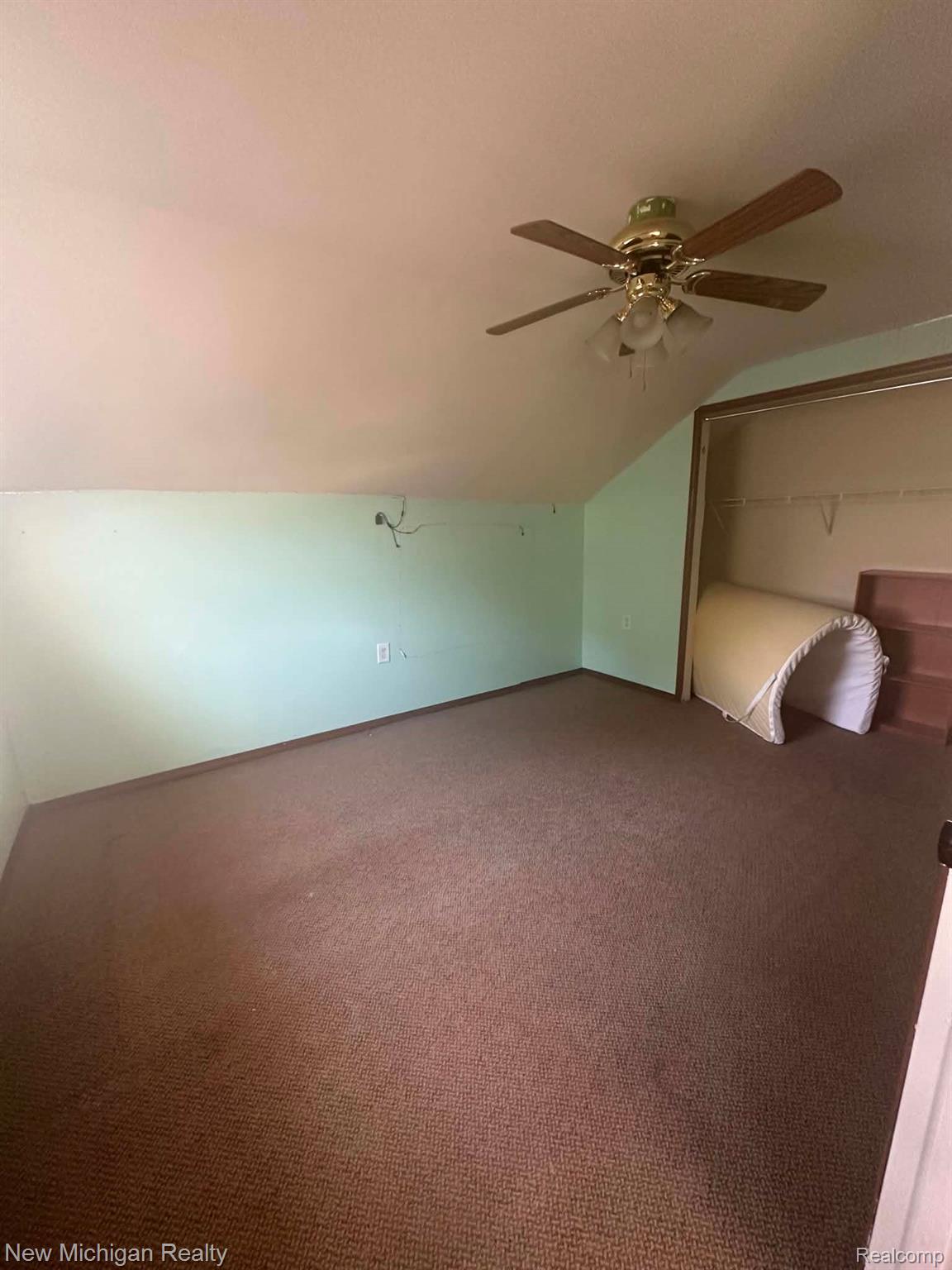 7415 Farrand Road Clio, MI 48420 - Photo 25 of 31 Carpeted room with a ceiling fan, sloped ceiling, and an open closet space
