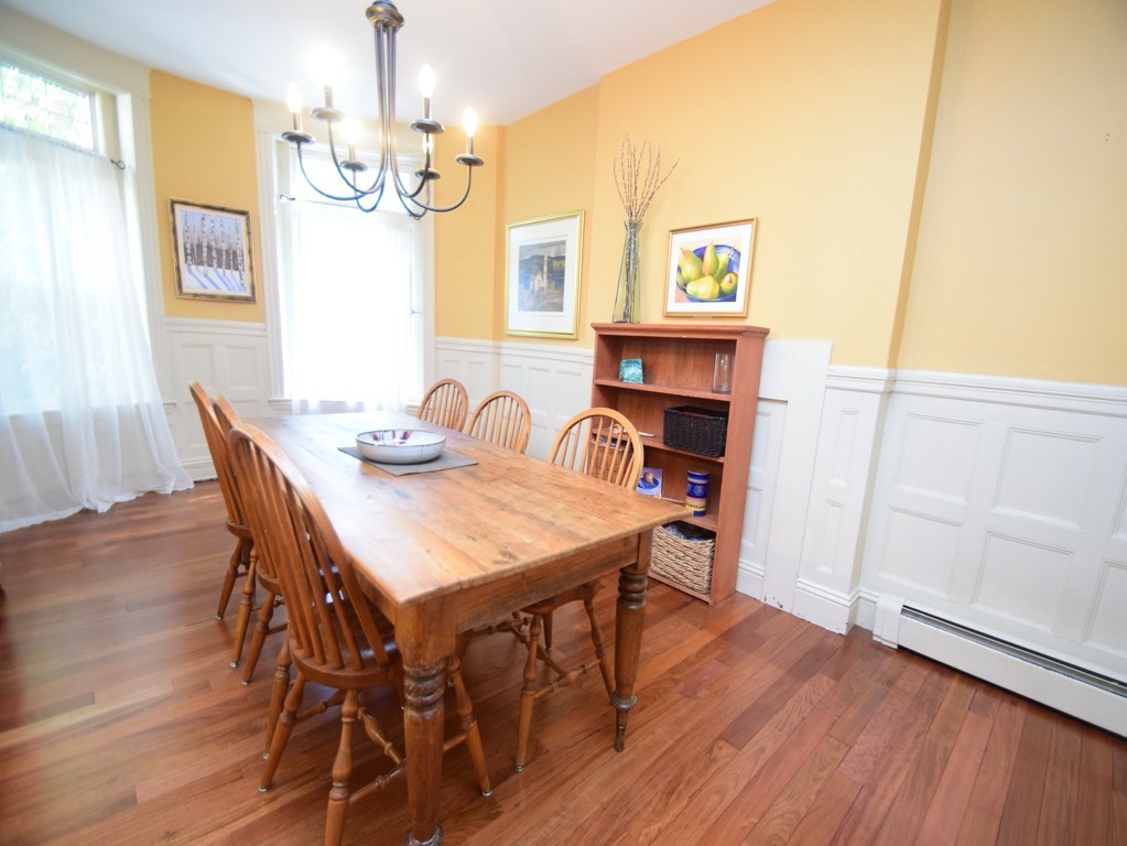 17 Strathmore Road, Unit 1 Brookline, MA 02445 - Photo 7 of 19 a dining room with wooden floor a chandelier a wooden table and chairs