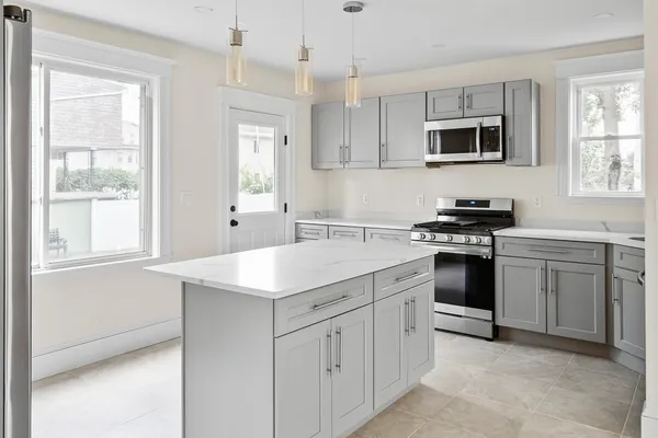 a kitchen with white cabinets and appliances