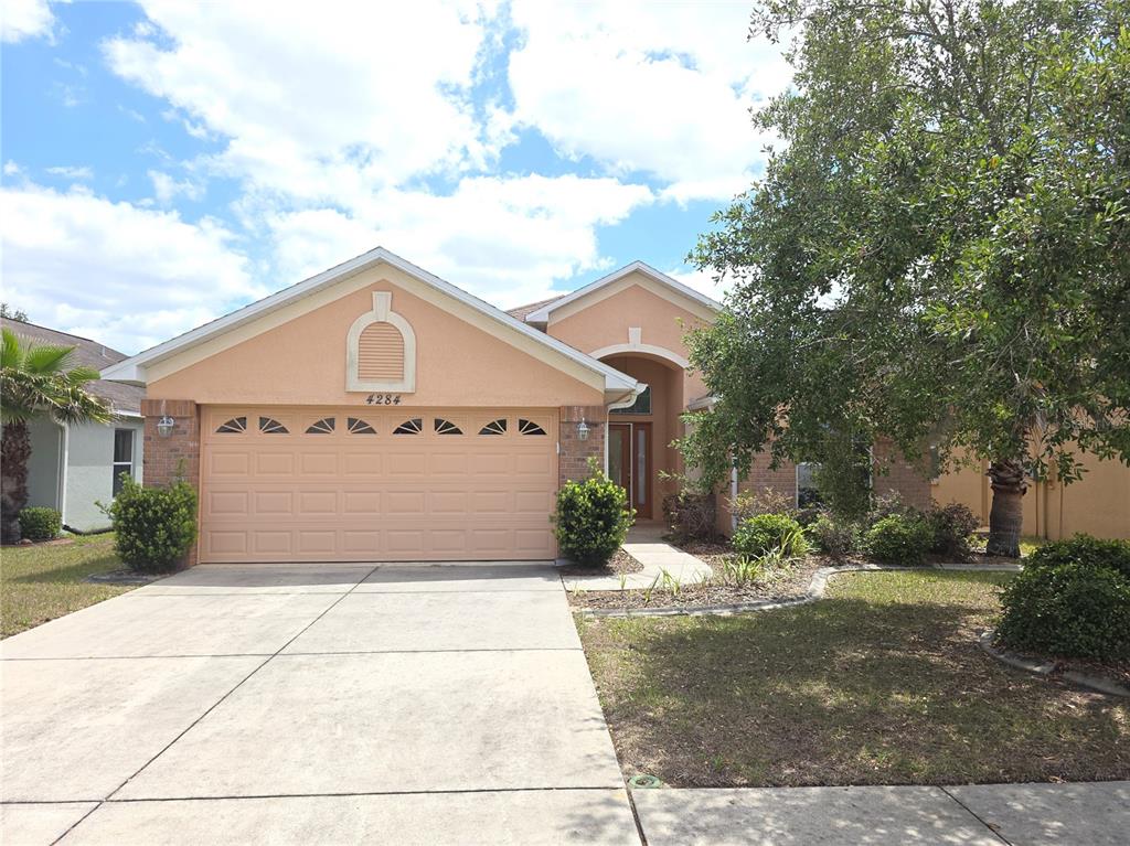 4284 High Ridge Avenue Spring Hill, FL 34609 - Photo 1 of 40 a front view of a house with a yard and garage