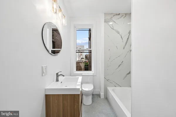 a bathroom with a toilet sink and mirror