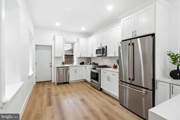 a kitchen with stainless steel appliances a refrigerator sink and microwave