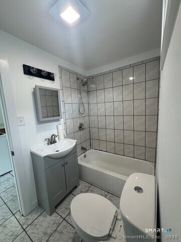 142 Cowles Street Bridgeport, CT 06607 - Photo 6 of 14 a bathroom with a toilet a sink a mirror and bathtub