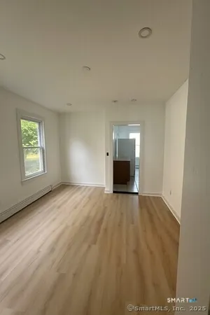 an empty room with windows and fireplace