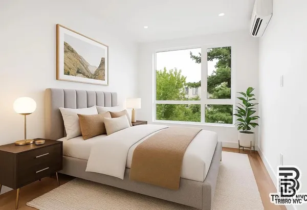 a large white bed sitting in a bedroom next to a window