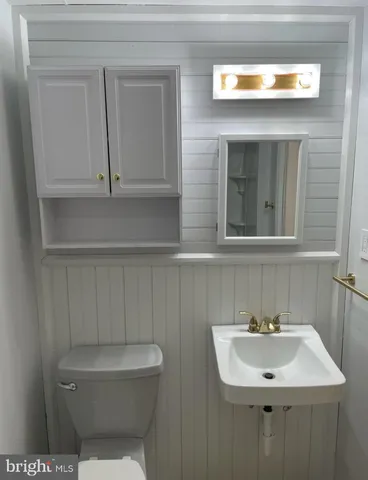 a bathroom with a toilet a sink and mirror