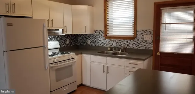 a kitchen with granite countertop white cabinets and white appliances