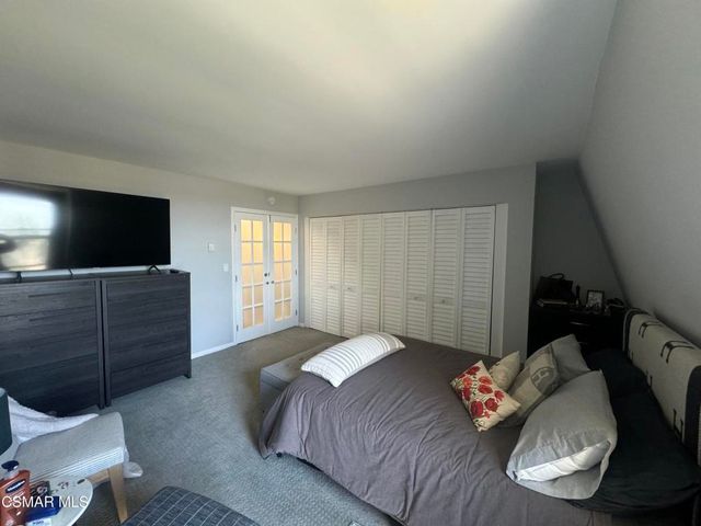 a bedroom with a bed and flat screen tv