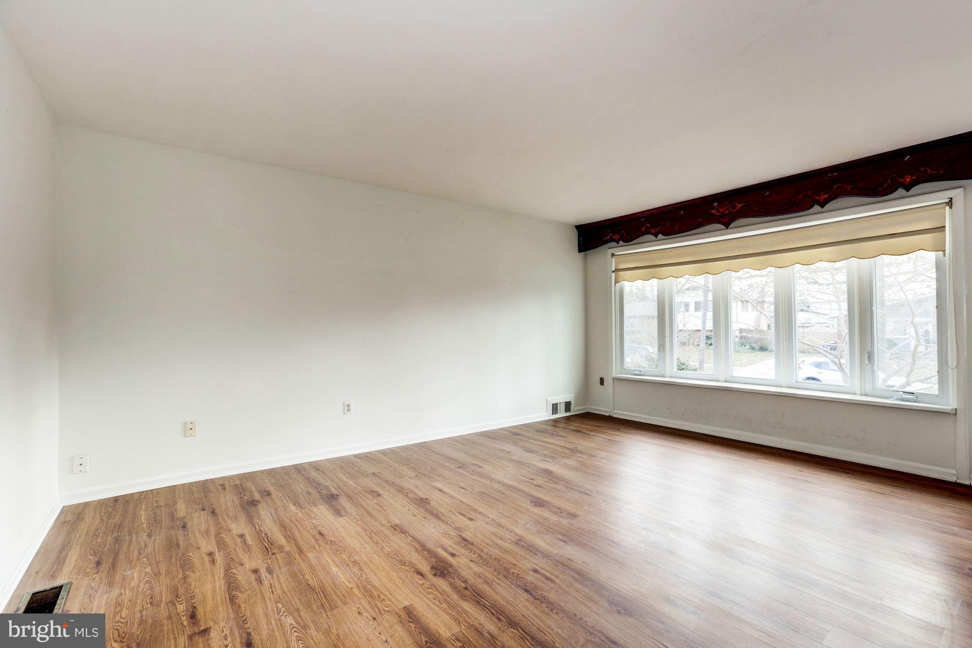12409 Littleton Street Silver Spring, MD 20906 - Photo 3 of 31 an empty room with wooden floor and windows