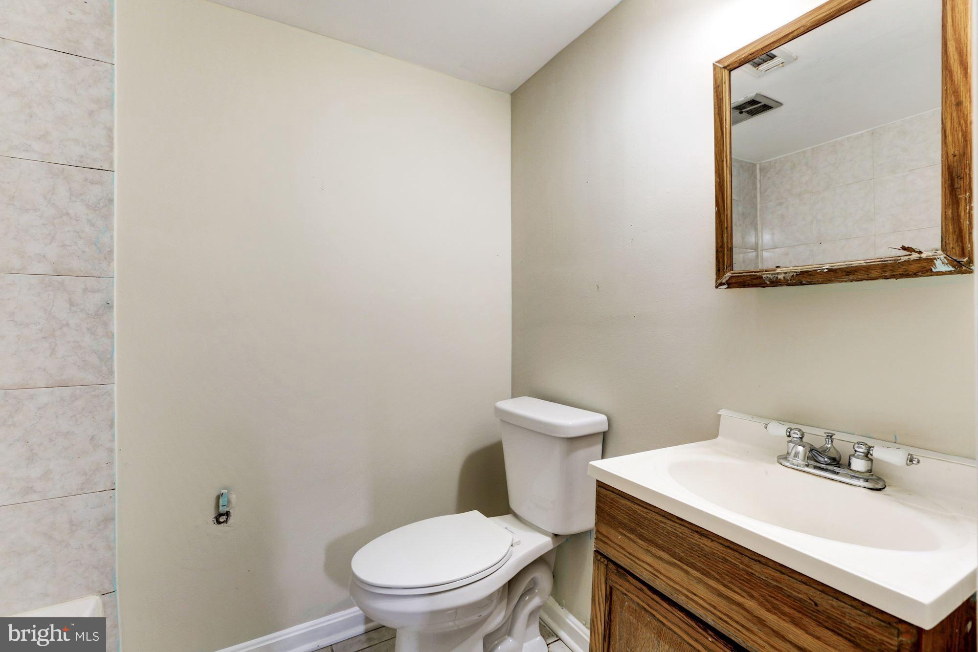 12409 Littleton Street Silver Spring, MD 20906 - Photo 25 of 31 a white toilet sitting next to a bathroom sink