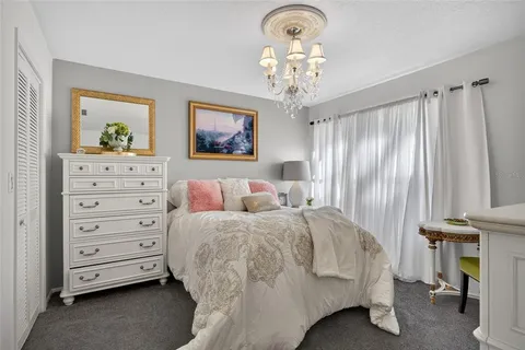 a spacious bedroom with a bed and a chandelier