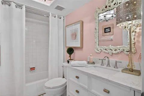 a bathroom with a granite countertop sink toilet a mirror a vanity and shower