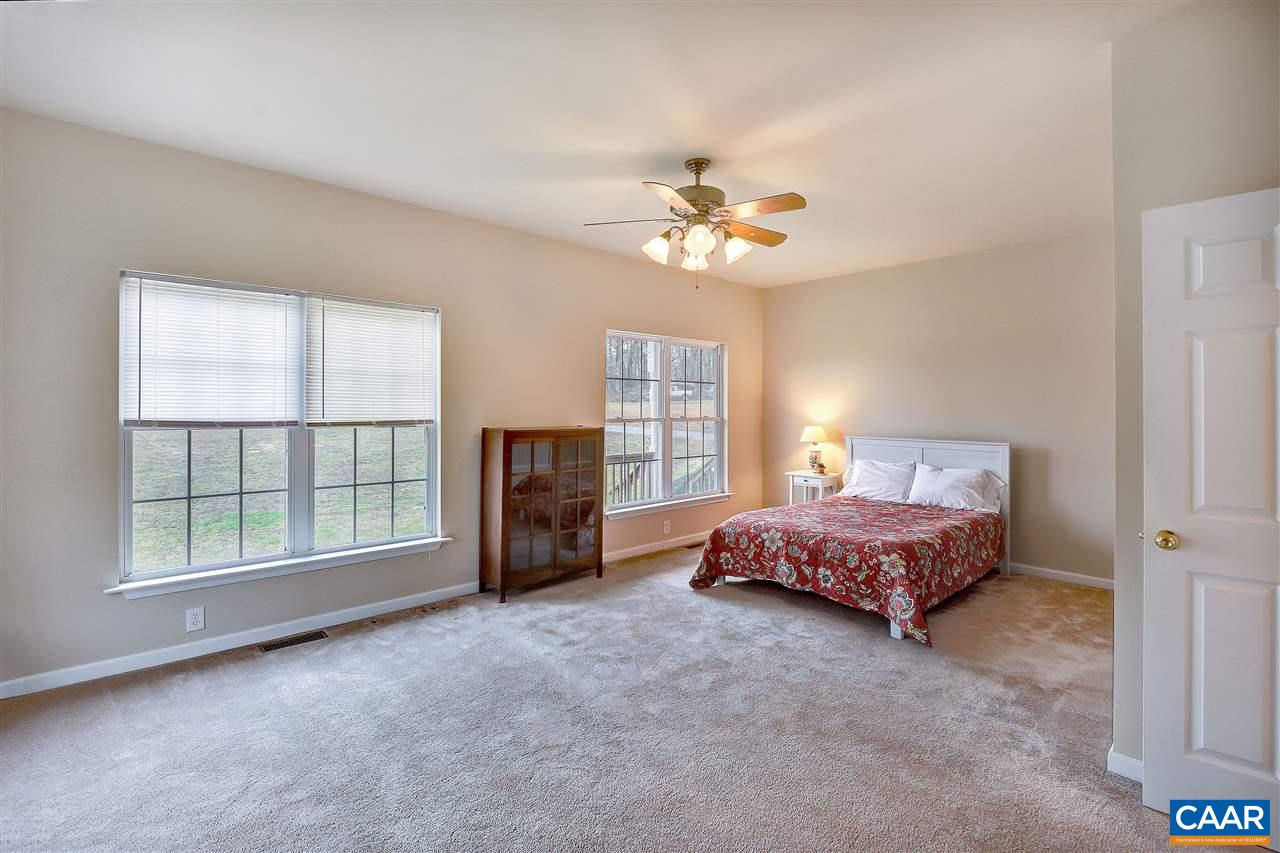 5875 Amicus Road Ruckersville, VA 22968 - Photo 15 of 31 a spacious bedroom with a bed and a chandelier