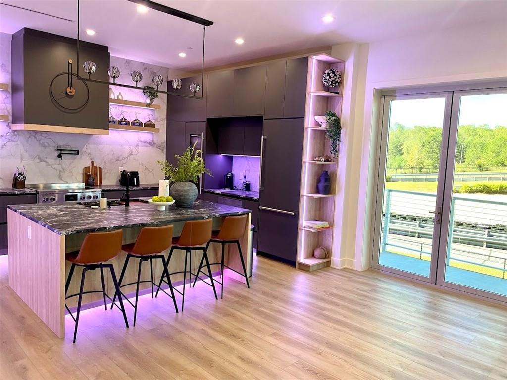 702 Joe Lane Cox Road, Unit 203 Dawsonville, GA 30534 - Photo 48 of 60 a kitchen with stainless steel appliances kitchen island granite countertop a refrigerator a sink a dining table and chairs with wooden floor