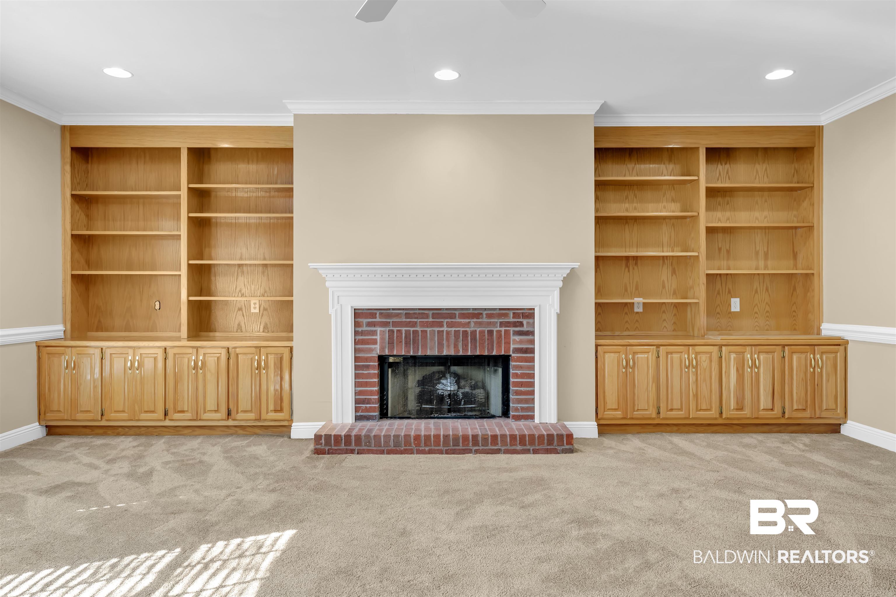 1262 Patrick Street Daphne, AL 36526 - Photo 9 of 35 Unfurnished living room with built in shelves, a brick fireplace, light colored carpet, crown molding, and recessed lighting