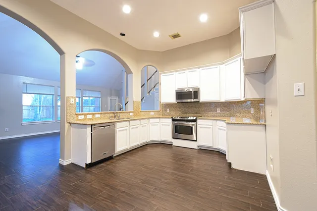 a kitchen with granite countertop white cabinets and white appliances