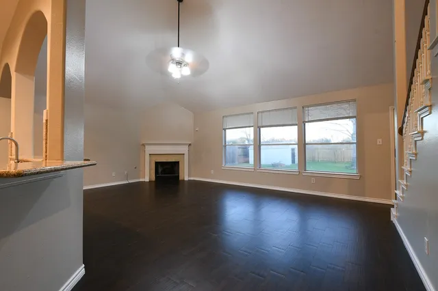 a view of empty room with wooden floor and fireplace