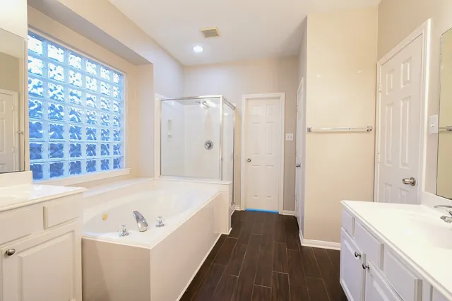 a spacious bathroom with a granite countertop sink a mirror and a bathtub