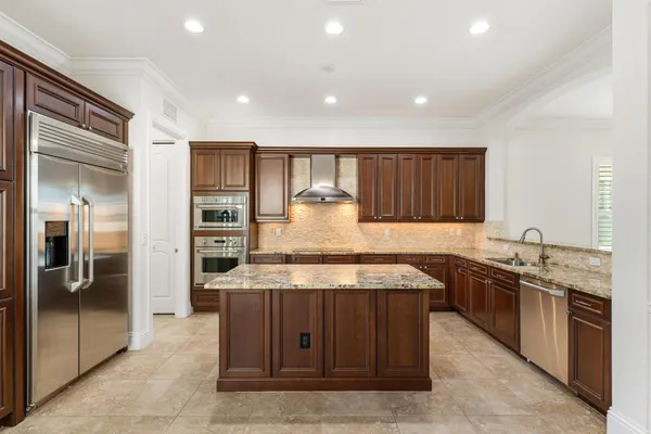 a kitchen with stainless steel appliances granite countertop wooden cabinets a sink and a stove