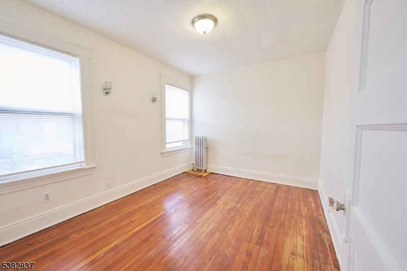 175 Madison Avenue, Unit 1 Elizabeth, NJ 07201 - Photo 5 of 10 an empty room with wooden floor and windows