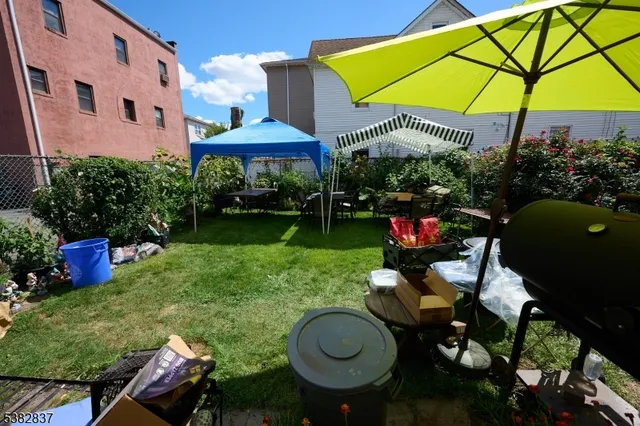 a view of a table and chairs under an umbrella in backyard