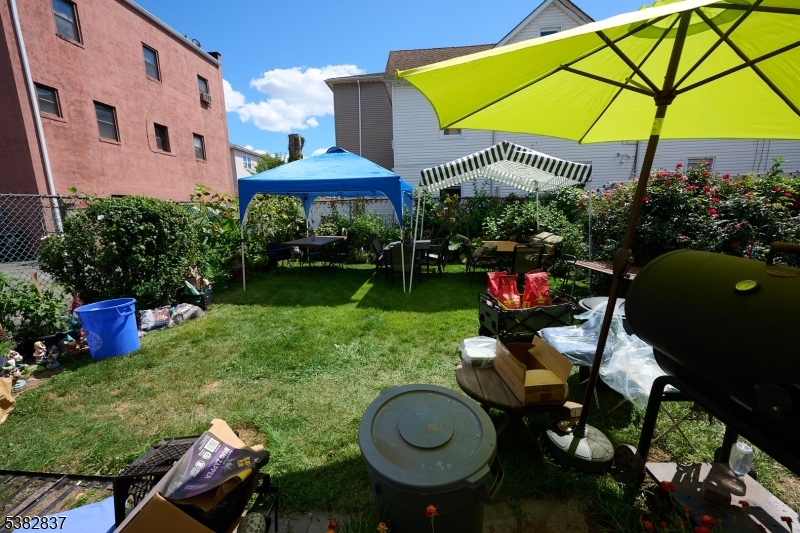 175 Madison Avenue, Unit 1 Elizabeth, NJ 07201 - Photo 8 of 10 a view of a table and chairs under an umbrella in backyard
