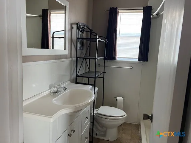 a bathroom with a sink toilet and mirror