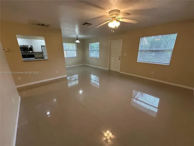 a view of a livingroom with furniture chandelier fan and windows