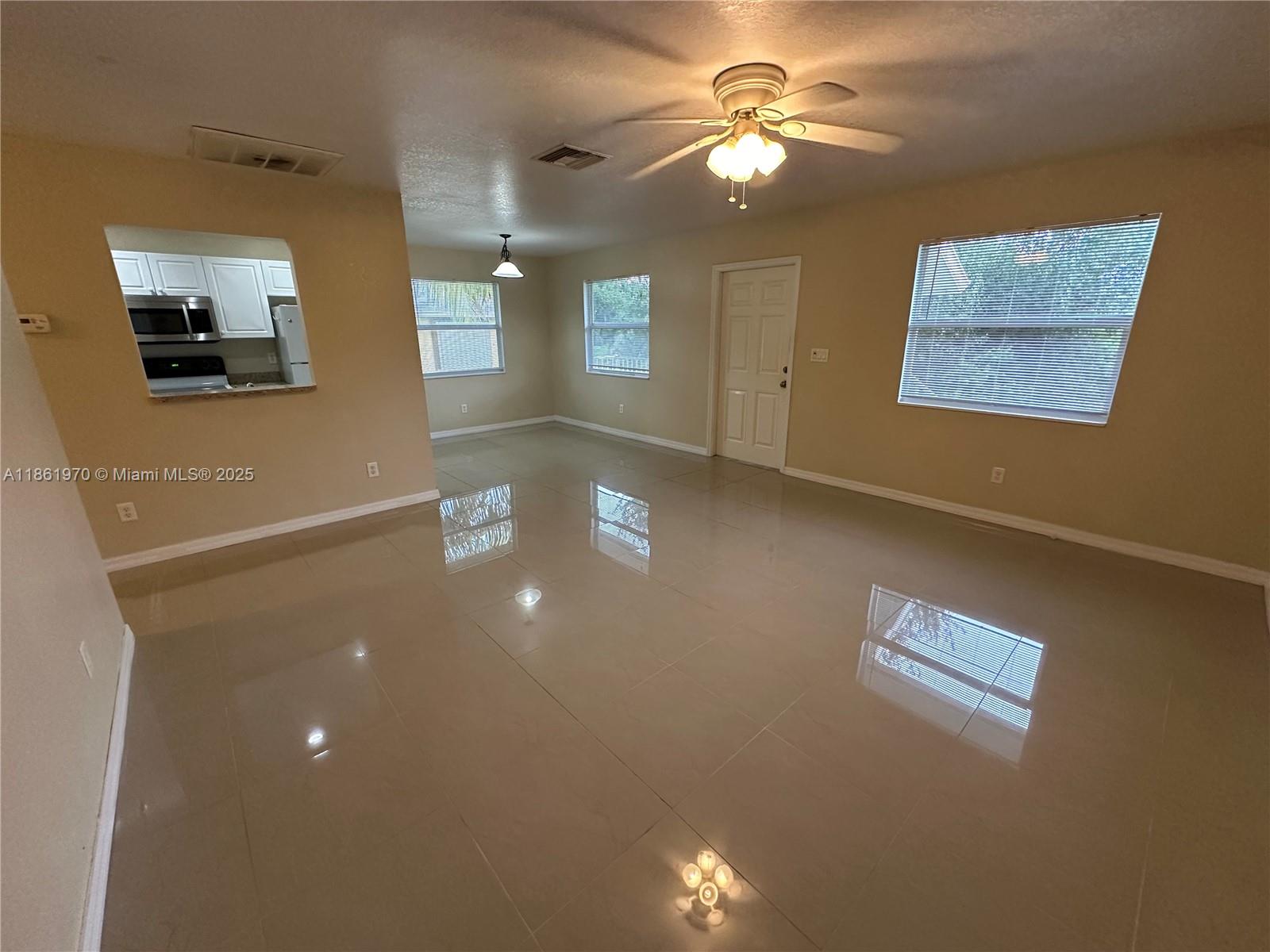 5548 Birdsong Lane, Unit 1 Bokeelia, FL 33922 - Photo 11 of 24 a view of a livingroom with furniture chandelier fan and windows